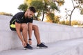 Young man with wireless headphones listening to music on stairs Royalty Free Stock Photo