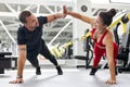 Young man and woman athletes doing push-ups during cross training at gym