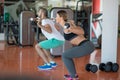 Young man and woman with barbell flexing muscles and making shoulder press squat in gym Royalty Free Stock Photo