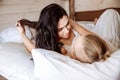 A young man and woman are basking in bed together. They are lying under a white sheets. Royalty Free Stock Photo