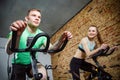 Young man and woman biking in the gym, exercising legs doing cardio workout cycling bikes. Royalty Free Stock Photo