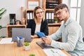 Young man and woman business workers using laptop and touchpad working at office Royalty Free Stock Photo