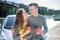 Young man and woman with coffee near a car. Royalty Free Stock Photo