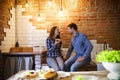 Young man and woman cooking and eating together at kitchen