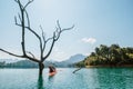 Young man and woman couple explorers travelers exploring the Cheow Lan lake in Thailand using a canoe