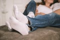 Young man and woman, couple in love lying on bed embracing legs in jeans, casual style, happy together Royalty Free Stock Photo