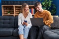 Young man and woman couple using laptop and credit card sitting on sofa at home Royalty Free Stock Photo