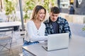 Young man and woman couple using laptop sitting on table at coffee shop terrace Royalty Free Stock Photo