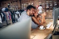 Young man and woman couple working in shop, looking at screen, brainstorming on a project idea together Royalty Free Stock Photo