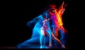 Young man and woman dancing hip-hop in sportive style clothes on dark background at dance hall in mixed neon light Royalty Free Stock Photo