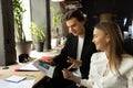 Working process at modern business company. Young man and woman discussing new tasks sitting at office table, indoors Royalty Free Stock Photo