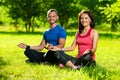 Young man and woman doing yoga in the sunny summer