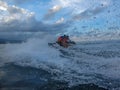 Young man and woman drifting across the sea surface. People on Jet Ski have fun in Ocean. Driver in action during splashing water. Royalty Free Stock Photo