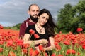 Young man and woman having date in the field of poppies Royalty Free Stock Photo