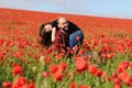 Young man and woman having date in the field of poppies Royalty Free Stock Photo