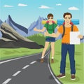 Young man and woman hitchhiking on road in mountains Royalty Free Stock Photo