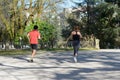 Young man and woman jogging in a city park