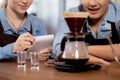Young man and woman learning making coffee with barista while pouring coffee at cafe, group people training drip coffee. Royalty Free Stock Photo