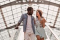 Young man and woman looking at each other standing on escalator in shopping mall Royalty Free Stock Photo