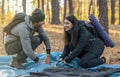 Young man and woman making tent together, having conversation Royalty Free Stock Photo