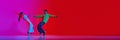 Young man and woman in notion, dancing hip hop against pink red background in neon light. Banner. Royalty Free Stock Photo
