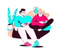 A young man and a woman play consoles while sitting on the couch together in a familiar home environment. The concept of