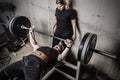 Young man and woman powerlifting in a gritty basement gym