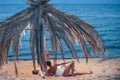 Young man and woman relax on sand by a sea on summer beach. Royalty Free Stock Photo