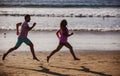 Young man and woman running jogging along the sea. Couple running on beach. Royalty Free Stock Photo