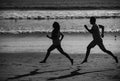 Young man and woman running jogging along the sea. Couple running on beach. Royalty Free Stock Photo