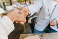 Young man and woman shaking hands during business meeting at cafe Royalty Free Stock Photo