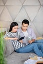 Young man and woman sitting on sofa with calculator and money. Royalty Free Stock Photo