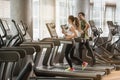 Young man and woman smiling while running side by side on treadmill Royalty Free Stock Photo