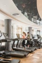 Young man and woman smiling while running side by side on treadmills Royalty Free Stock Photo