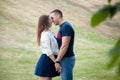 Young man and woman snuggling in park