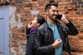 Young man and woman stand nearby back to back, talking on their cell phones Royalty Free Stock Photo