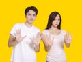 Young man and woman standing with outstretched hand showing stop sign Royalty Free Stock Photo