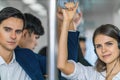 Young man and woman standing in subway train going to working in morning Royalty Free Stock Photo