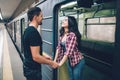 Young man and woman use underground. Couple in subway. Young brunette stand in underground carriage and smile. She hold Royalty Free Stock Photo