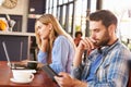 Young man and woman using computers at a coffee shop Royalty Free Stock Photo