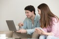 Young man and woman using laptop, tablet, talking, shopping onli