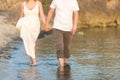 Young man and woman walking on the beach together at sunset, body closeup Royalty Free Stock Photo