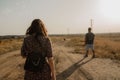 a young man and woman walking down the dirt road on a farm Royalty Free Stock Photo