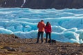 Young Man and woman watching and navigating a flying drone in blue clear Sky before of beautiful evening scenery of Skaftafell Royalty Free Stock Photo