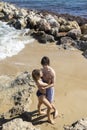 young man and woman about 20 years old, a couple in love, in full growth gently hugging on the beach Royalty Free Stock Photo