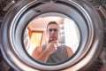 Young man wondering how the washing machine works. Royalty Free Stock Photo