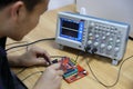 Electronic devices and Circuit board Ã¯Â¼Åmale electronic engineer using oscilloscope in laboratory