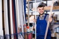 Young man worker examining plastic corners for tiles and floors Royalty Free Stock Photo