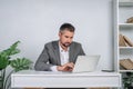 A young man is working behind a laptop in his office. The teacher prepares for the lecture. Royalty Free Stock Photo