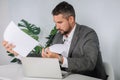 A young man is working behind a laptop in his office. The teacher prepares for the lecture. Royalty Free Stock Photo